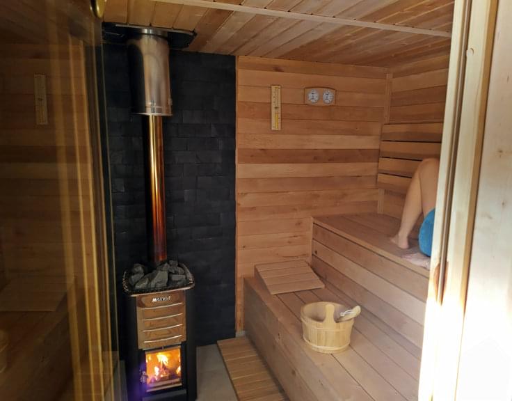 sauna w srodku, piec i drewniane ławy