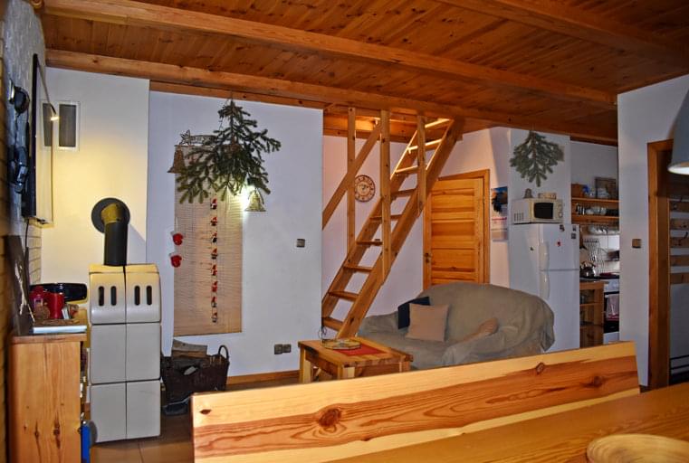 salon z kanapą i wejściem na poddasze